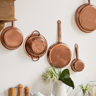 hanging-kitchen-utensil-wall-different-cookware-plates-tabletop-wooden-kitchen 1